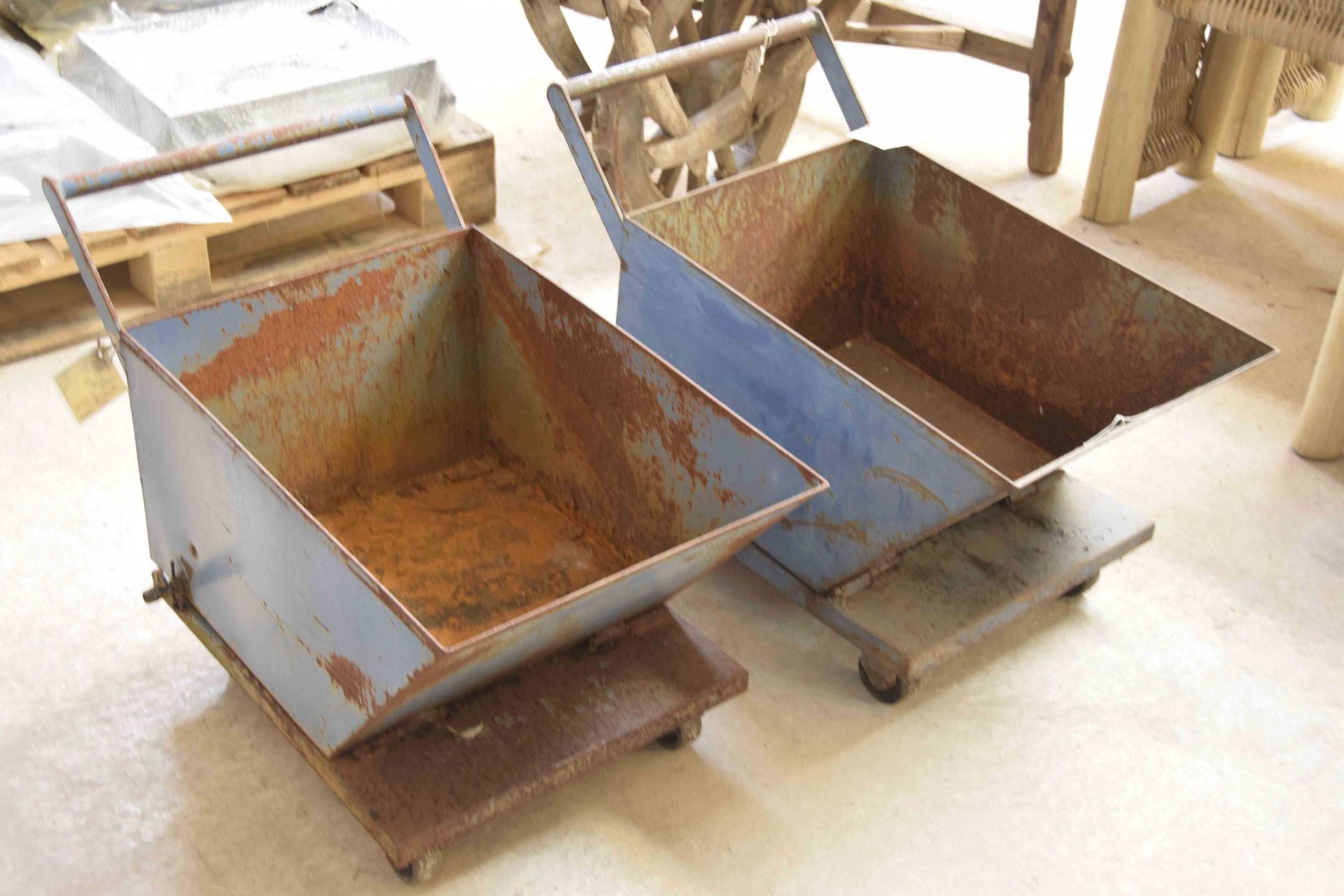 A pair of blue wheeled feed bins