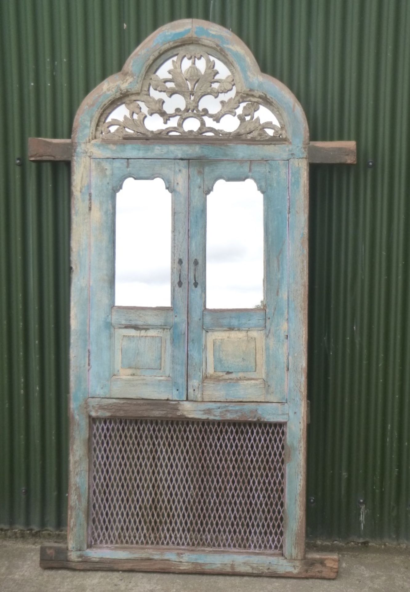Mirror blue panelled set of teak windowed doors and iron decorative ventilator.