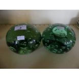 A pair of large green glass dump paperweights