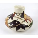 A large Moorcroft pottery vase of squat form Decorated with fruit and foliate on an ivory ground,