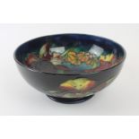 A Walter Moorcroft pedestal bowl Decorated in the Orchid pattern on a blue ground,