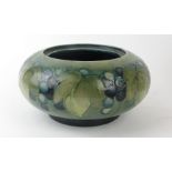 A Walter Moorcroft bowl of circular form Decorated in the Leaf & Berry pattern on a green ground,