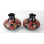 A pair of William Moorcroft pottery vases Each of squat form decorated in the Pomegranate pattern