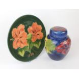 A Walter Moorcroft pottery ginger jar and cover Decorated in the Hibiscus pattern on a blue ground,