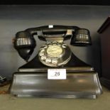 A vintage black bakelite telephone.