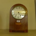 An Edwardian mantel clock of arched form with silvered dial.