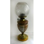 A late 19th Century oil lamp With ceramic body removable glass font and circular brass loaded base,