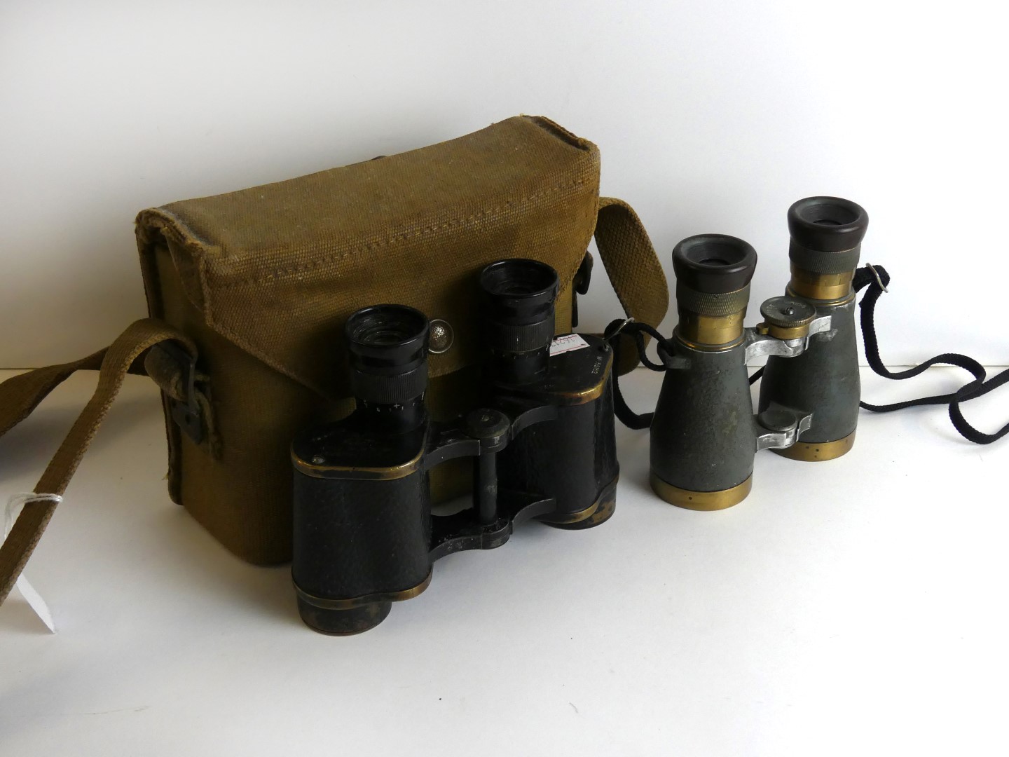 A cased pair of WWII military issue binoculars Kershaw binoculars in a canvas case by Finnigans Ltd