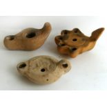 Three pottery oil lamps, probably Ancient Roman One lamp with five burners and leaf handle,