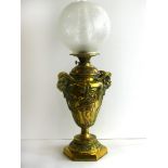 A 19th Century brass oil lamp Formed as a classical vase with goats head handles and decorated with