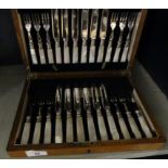 An oak cased canteen of mother of pearl handled dessert cutlery