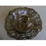 Three white metal bowls to include a floral embossed bowl with two others