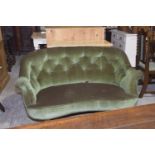 An early 20th Century oak and upholstered kidney shaped settee Having a button padded back above a