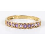 An amethyst band ring The circular shape amethyst line with grooved sides, stamped 9k, ring size