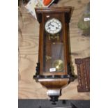 A Victorian walnut cased Vienna style wall clock Having a 13cm enameled white dial painted with