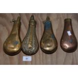 A group of four copper powder flasks Each of typical form. Three plain, the fourth decorated in