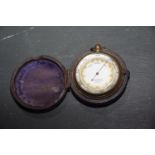 A Callaghan & Company cased pocket barometer, early 20th Century With central dial with marks for '