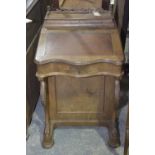 A Victorian walnut Davenport The serpentine hinged top above two carved curvilinear supports and a