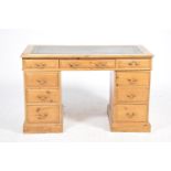 A pine twin pedestal writing desk The rectangular moulded top inset with a gilt tooled leather