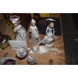 A collection of Lladro figures To include a lady in gown, a lady with an umbrella, a lady with a