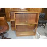 A pair of Gibbs furniture teak glazed bookcases Each bookcase with an arrangement of two sliding