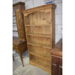 A modern pine free standing bookcase With a moulded cornice above four fixed shelves, raised upon