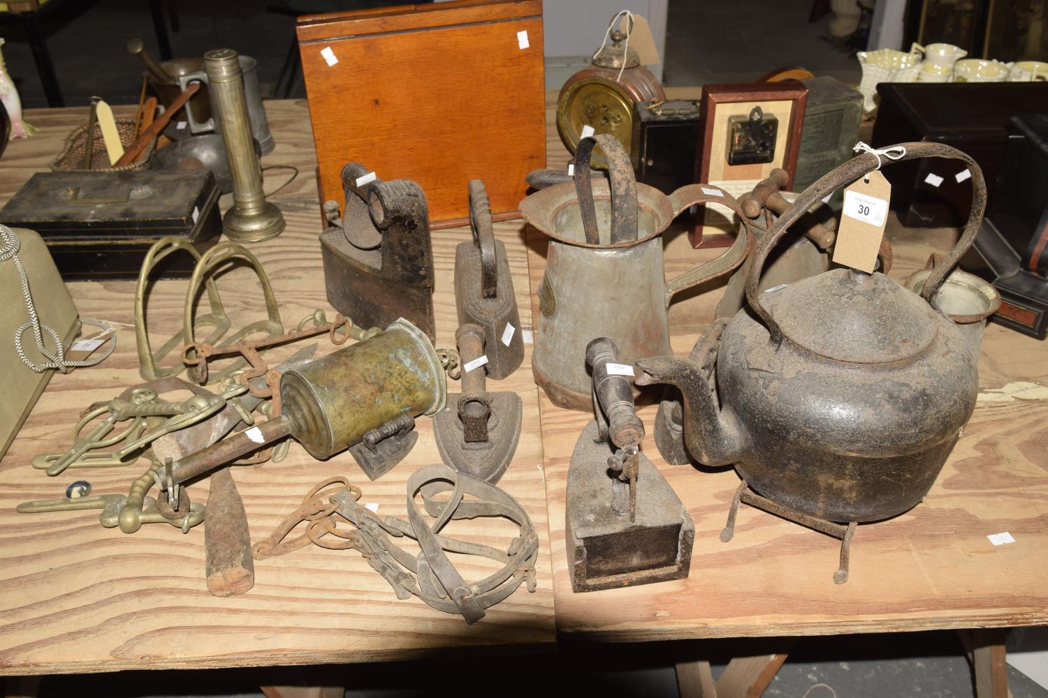 A collection of iron works To include four flat irons, stirrups, kettle, three jugs - two jugs