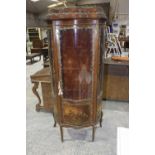 A French walnut vitrine, 20th Century The serpentine front cabinet extensively applied with gilt