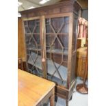 A 19th Century mahogany glazed bookcase Having a dentil moulded cornice above a plain frieze and two