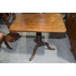 A Georgian mahogany tripod table The rectangular top with rounded corners on a knopped shaft with