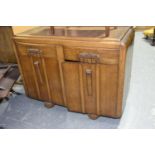 A 1940's oak sideboard Having a rectangular moulded top above rounded sides, two frieze drawers