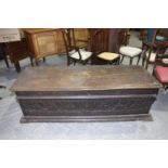 A 17th Century oak cassone The substantial rectangular hinged top above a chiseled frieze and a