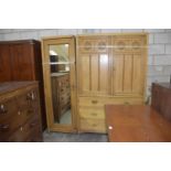 A late Victorian ash compactum wardrobe Having a full length mirrored door opposed by two panelled