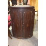 A George III mahogany bow front hanging corner cupboard Each door centred with an inlaid shell