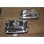 A pair of silver plated entree dishes The cushion shaped dishes with gadroon borders, and scroll