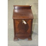 An Edwardian mahogany coal perdonium Having a square top above a fall front raised upon ogee bracket