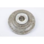 An unusual variegated stone wall barometer The stepped circular frame enclosing a white enamel
