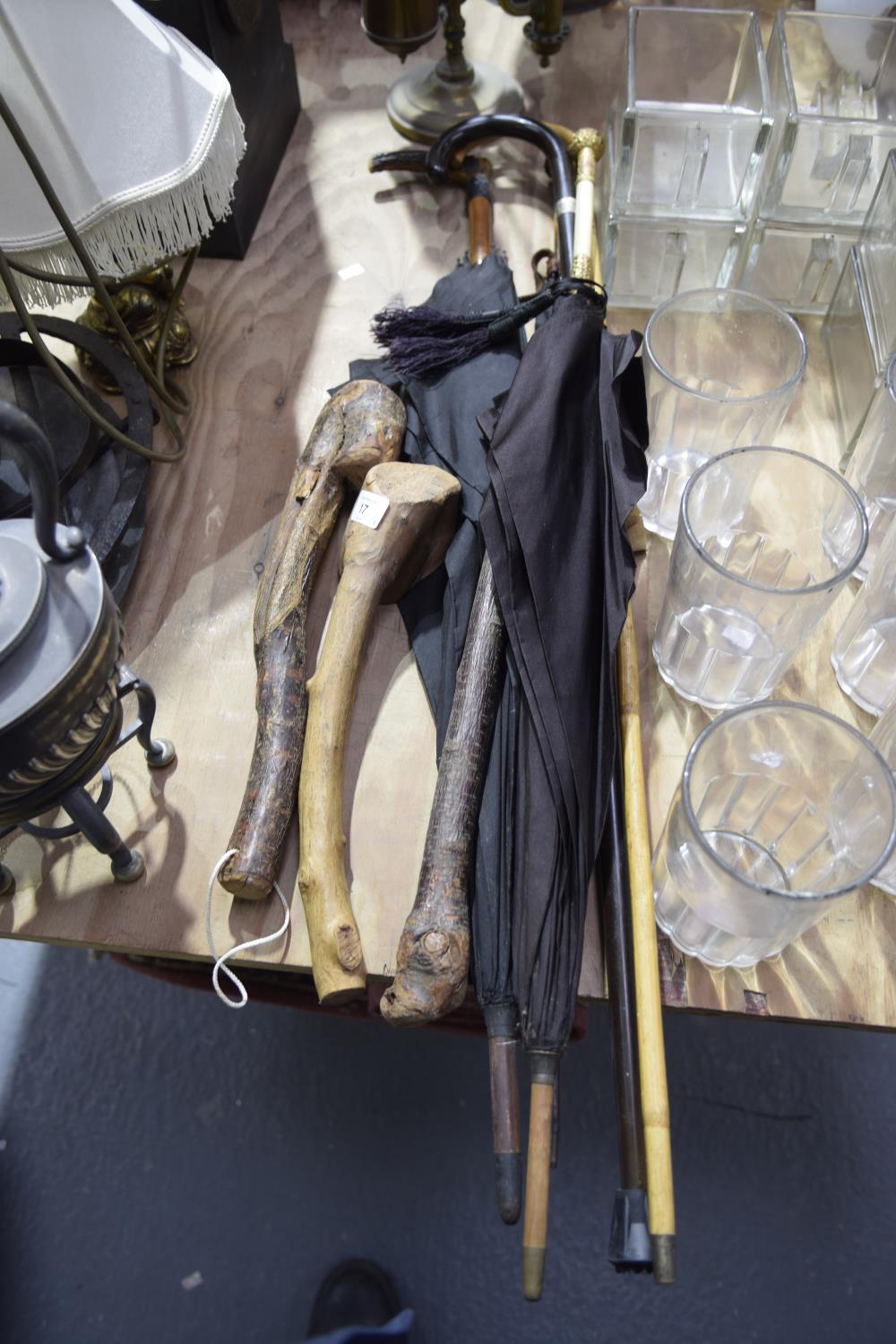 A collection of walking canes and umbrellas To include three hardwood priests, a wooden walking