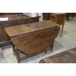 A 19th Century oval oak drop leaf dining table Having a single frieze drawer, raised upon ring