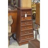 A modern hardwood pyramid chest of drawers Having a square molded top above six graduated drawers