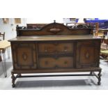 A 1920's oak Jacobean revival sideboard The raised back with a leafy openwork frieze above the