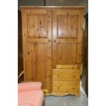 A modern pine compactum wardrobe Having a moulded cornice above full length door apposed by a