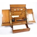 An early 20th Century golden oak folding stationery box The sloping hinged doors enclosing a