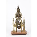 A late 19th Century brass skeleton clock The finely pierced and cast brass clock of Cathedral form