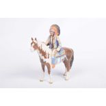 A Beswick figure of a red Indian The red Indian in traditional dress modeled seated on a skewbald