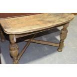 A 1920's oak draw leaf extending dining table The square top with bow front ends and two draw leaves