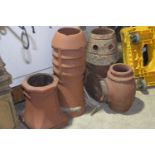 Four early 20th Century red stone chimney pots To include cylindrical vented example, a twin