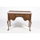 An early 20th Century mahogany low boy or desk The rectangular top with canted front corners above