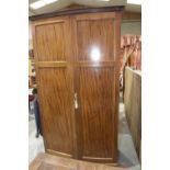 A mahogany Georgian style bow front wardrobe Having a Greek key pattern frieze above two paneled