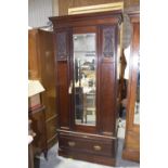 A late Victorian walnut wardrobe Having a cavetto cornice above a central mirrored door and a